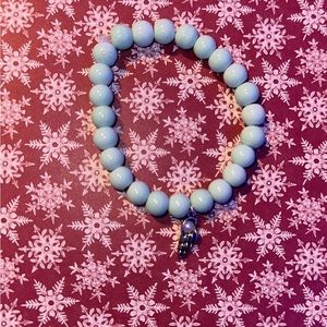 teal green bracelet with a feather charm attached to the bottom